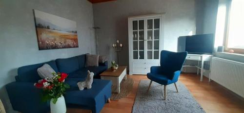 a living room with a blue couch and blue chairs at Haus am Bach in Miehlen