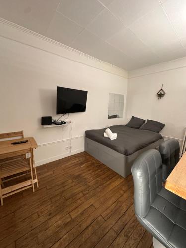 sypialnia z łóżkiem i telewizorem na ścianie w obiekcie Studio idéal proche centre Paris w mieście Boulogne-Billancourt