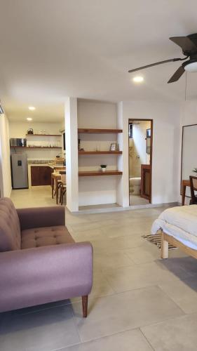 a living room with a couch and a kitchen at Modern loft with AC near Paseo Montejo - El Rosal in Mérida