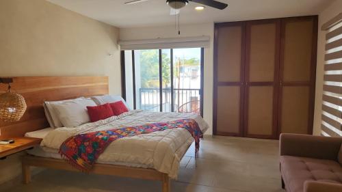 a bedroom with a bed and a sliding glass door at Modern loft with AC near Paseo Montejo - El Rosal in Mérida