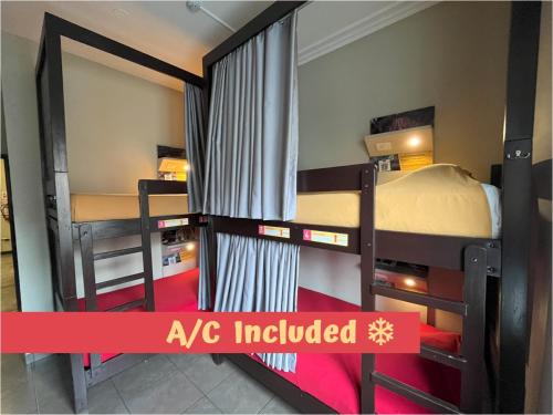 two bunk beds in a room with a sign that says ak included at Pariwana Hostel Lima in Lima