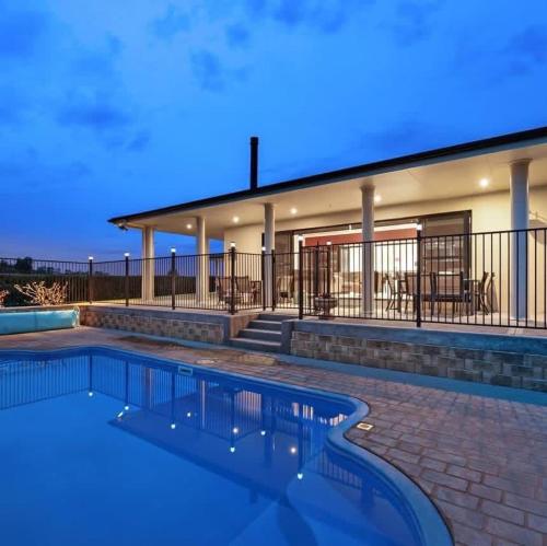 a swimming pool in front of a house at Mudgee Gardens Stayz in Mudgee