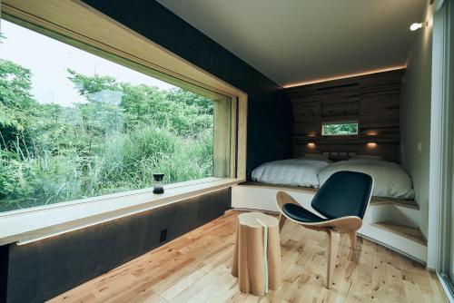 a bedroom with a window and a bed and a chair at BLANC FUJI in Fujiyoshida