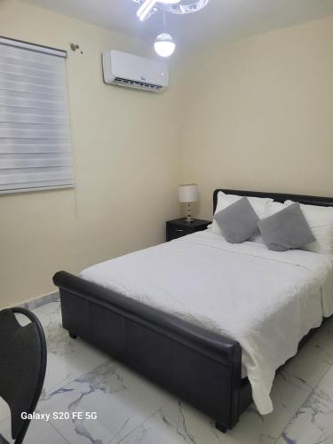 a bedroom with a large bed with white sheets and pillows at bienvenido a casa in San Pedro de Macorís