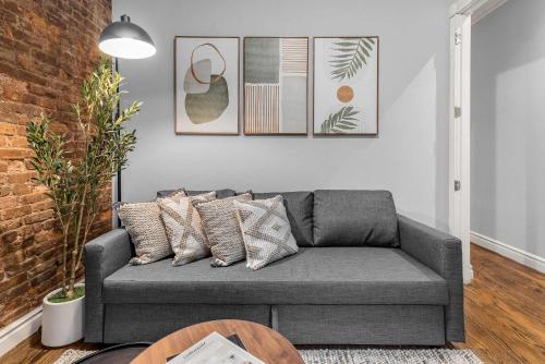 a living room with a gray couch and a table at Bold Manhattan Base in Prime Nolita in New York