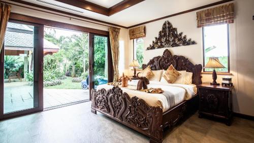 um quarto com uma cama grande e uma janela grande em Saifon Villas 5 Bedroom Pool Villa - Whole villa priced by bedrooms occupied em Praia de Ao Nang