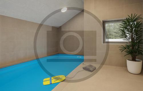 a swimming pool with a yellow and blue water at Pet Friendly Home In Faaborg With Sauna in Faaborg