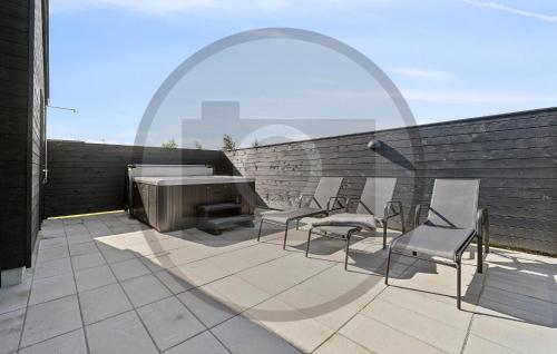 a patio with chairs and a fireplace on a brick wall at Pet Friendly Home In Faaborg With Sauna in Faaborg
