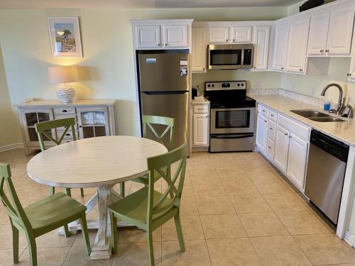 a kitchen with a table and a refrigerator at Beachgate Condo Suites and Hotel 533 condo in Port Aransas