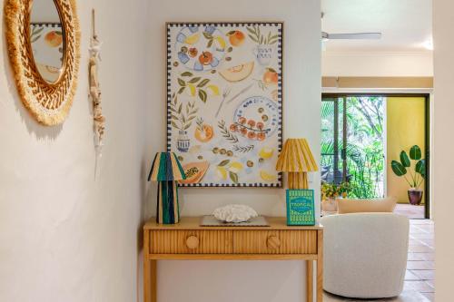 a mirror on a wall above a wooden table at Let's Get Tropical, Located In The Heart Of Town, 2 King Beds, 2 Pools, 2 Bathrooms in Port Douglas