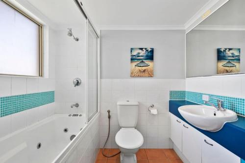 a bathroom with a white toilet and a sink at Whale Point in Yaroomba
