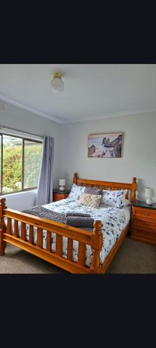 a bedroom with a wooden bed and a window at Ocean views in Portland