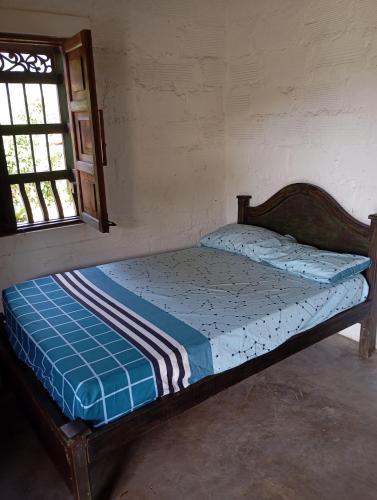 a small bed in a room with a window at La Luna cabin in Amagá