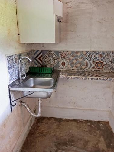 a kitchen with a sink and tiles on the wall at La Luna cabin in Amagá