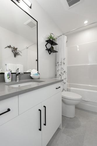 a white bathroom with a sink and a toilet at Cozy Corner on Trumpeter in Colwood