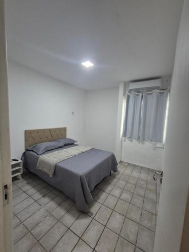 a bedroom with a bed in a white room at Casa com piscina in Petrolina
