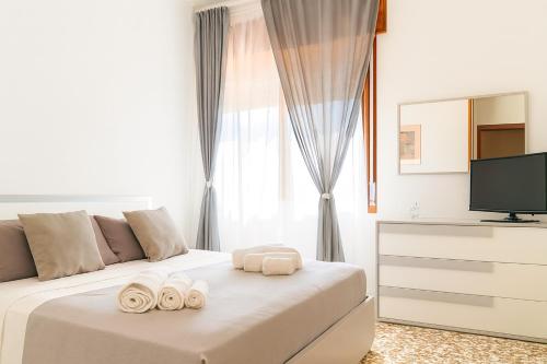 a white bedroom with a bed with towels on it at Exclusive Large 3 bed room Apartment with Pool Central Sorrento in Sorrento
