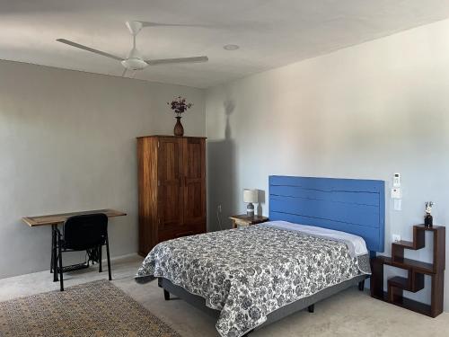 a bedroom with a blue bed and a desk at Casa Azul en Centro de Mérida in Mérida