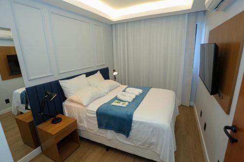 a bedroom with a bed with towels on it at Flat Rosarinho - Confortável e Super Completo in Recife