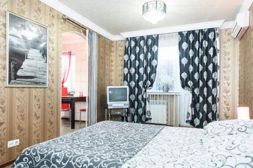 a bedroom with a bed and a television in it at Apartment on Nezalezhnoy Ukrаiny near Intourist Hotel in Zaporozhye