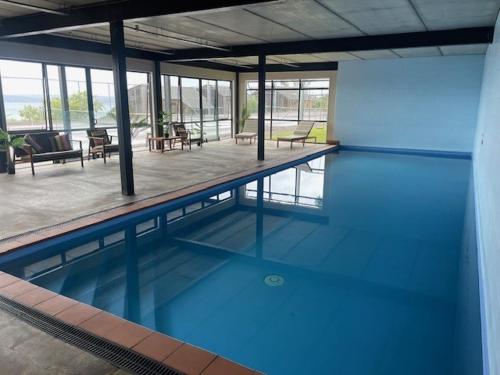 a large swimming pool with blue water in a building at Pukawa Villas Formerly Oreti Village Resort in Kuratau