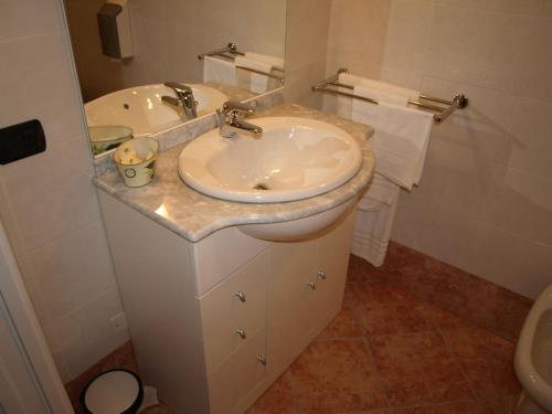 a white bathroom with a sink and a toilet at Hotel Karol in Monza