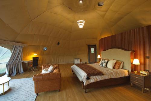 a bedroom with a large bed and a couch at One life Glamping Tent in Rawson