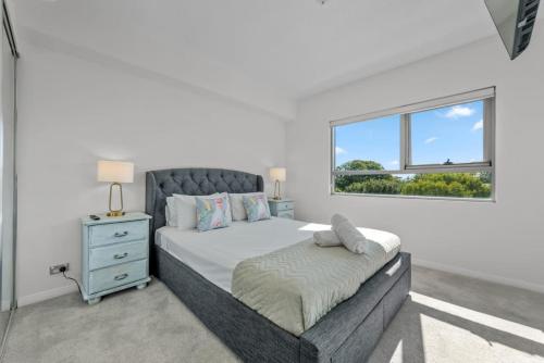 a bedroom with a large bed and a window at Proximity Waterfront Apartments in Redcliffe