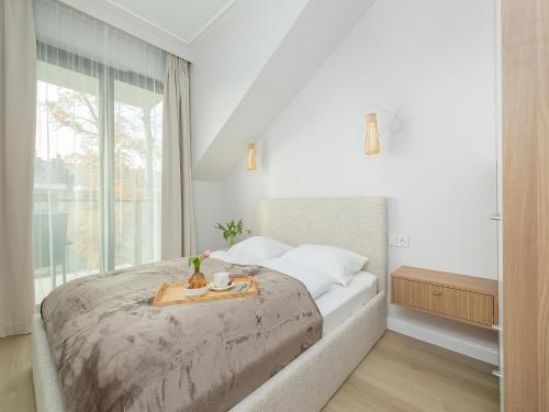 a bedroom with a large bed with a tray on it at Comfortable apartment, right on the beach in Niechorze