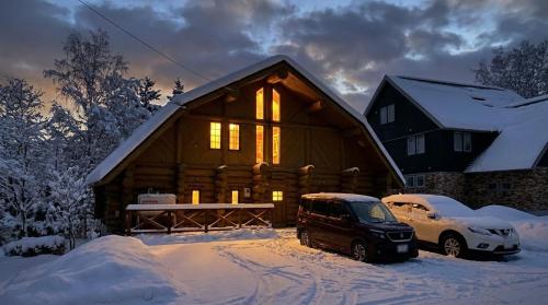 a log cabin with a van parked in the snow at Terrace Niseko Glide in Kutchan