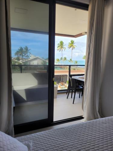 a bedroom with a bed and a view of the ocean at Resort Cais Eco Residence in Ipojuca