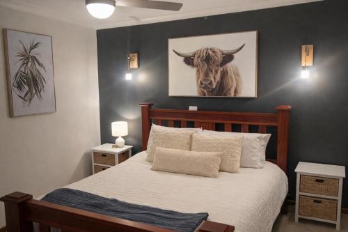 a bedroom with a bed with a picture of a cow at Rest, Relax and Recoup in Lake Albert