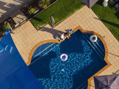 an overhead view of a swimming pool with an umbrella at BIG4 Tasman Holiday Parks - Bendigo in Bendigo