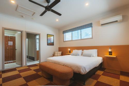 a bedroom with a large bed and a ceiling fan at Hotel Allen in Townsville