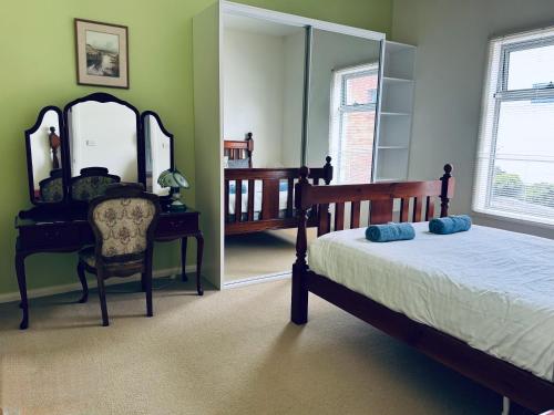 a bedroom with a bed and a mirror and a chair at True Blue One in Sheffield