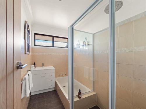 a bathroom with a shower and a tub and a sink at Little Margs in Margaret River Town