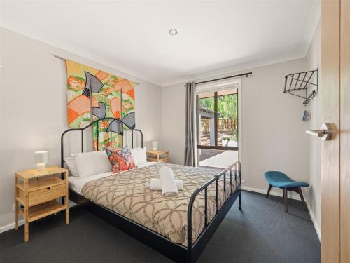 a bedroom with a bed with a painting on the wall at Little Margs in Margaret River Town