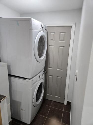 a washer and dryer in a room with a door at Peaceful escape in Ottawa