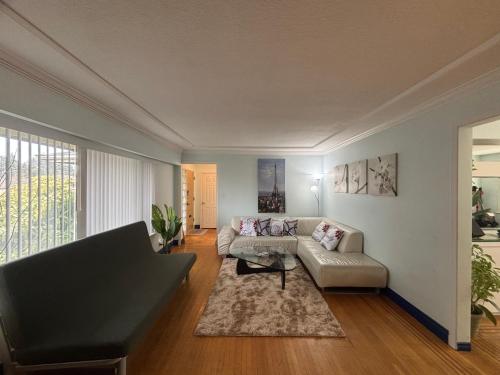 a living room with a couch and a table at Charming Bright 3BR House - Upper Level Suite in Burnaby