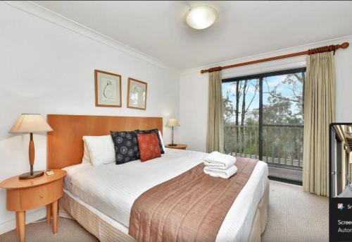 a bedroom with a large bed and a window at Villa Rose with Free Wine Tasting Included in Pokolbin