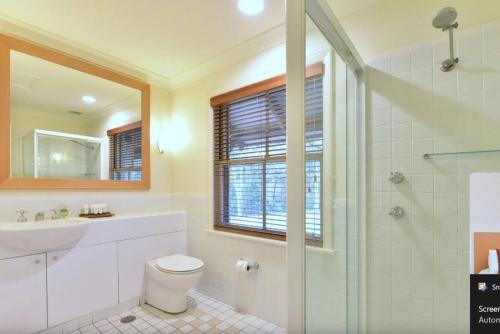 a bathroom with a toilet and a sink and a shower at Villa Rose with Free Wine Tasting Included in Pokolbin