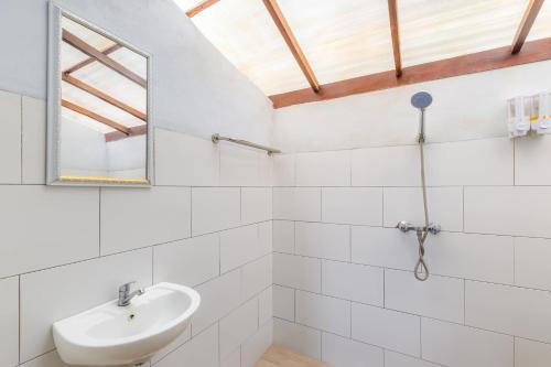 a white bathroom with a sink and a mirror at La Rise Penida Cottage in Nusa Penida