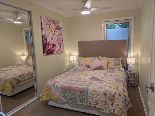a bedroom with a large bed and a mirror at Phoenix Oasis, Family and Pet friendly, with private pool and spa in Port Macquarie