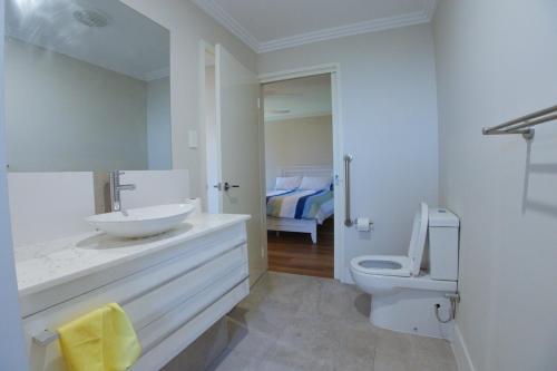 a white bathroom with a sink and a toilet at South West Retreat in Bunbury