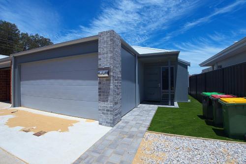 a garage with a garage door and a fence at South West Retreat in Bunbury