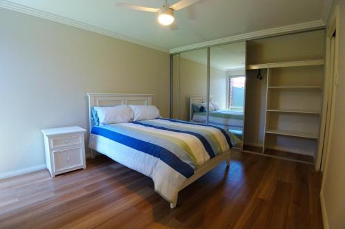 a bedroom with a bed and a large mirror at South West Retreat in Bunbury