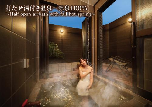a woman standing in a hot tub in a bathroom at 湯宿灯火 in Beppu