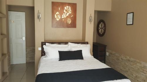 um quarto com uma cama com uma almofada preta em Ditsaleng Bed and Breakfast em Vanderbijlpark