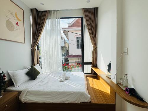 a bedroom with a bed and a large window at Tue Anh Homestay in Cồn Giả Viên