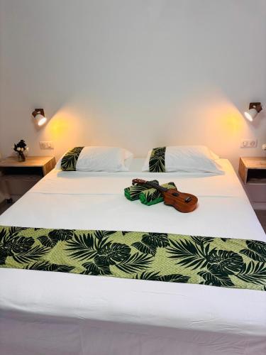 two beds with white sheets and a pair of shoes on them at Airport Pamatai Studio in Faaa